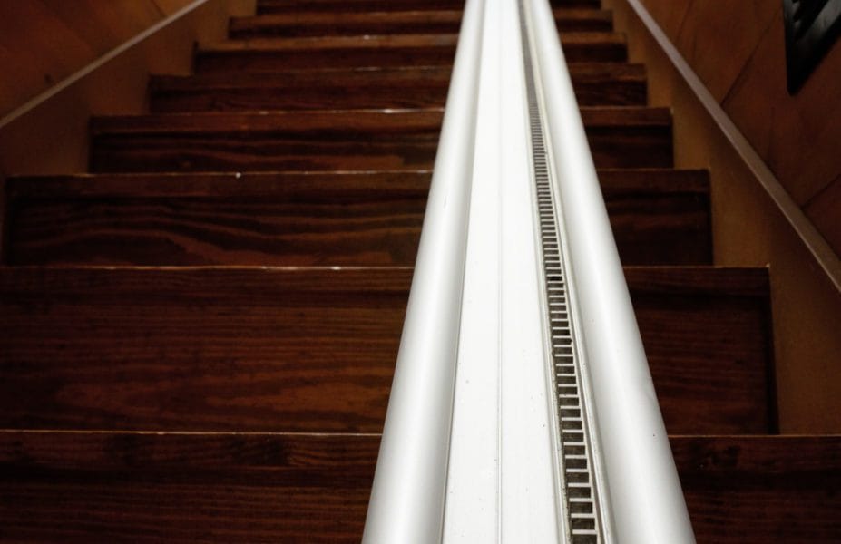 Wooden staircase with a white handrail.