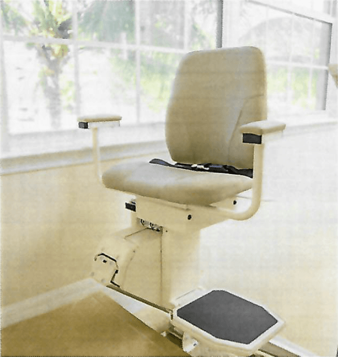 A stairlift chair in front of a large window overlooking greenery.