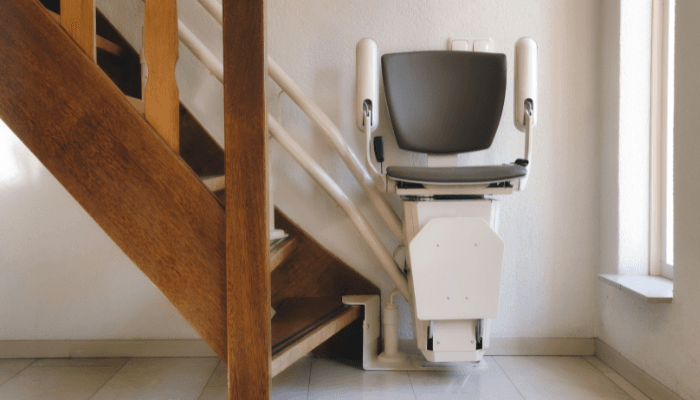 A white chair lift built on the stairs.
